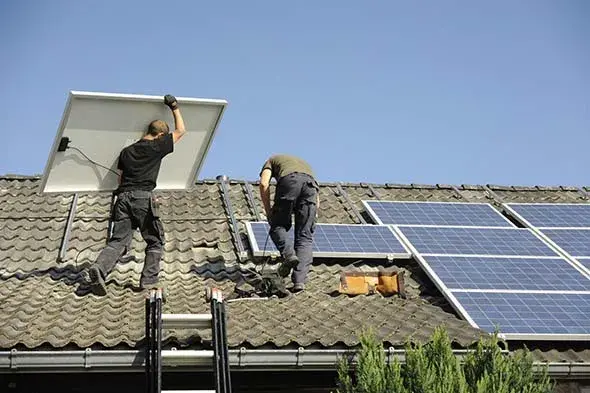 wrokers in peakbuilders orange county installing a solar panels on roof